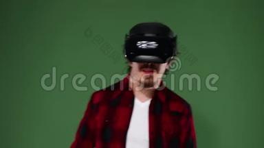 年轻人卷发使用VR耳机，体验虚拟现实隔离在绿色背景。 铬钥匙。